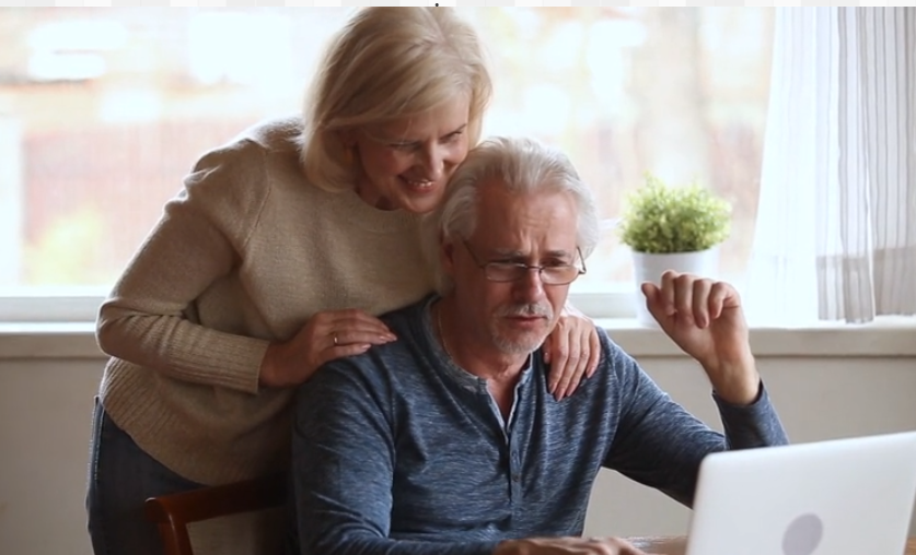 un couple assis devant un ordinateur